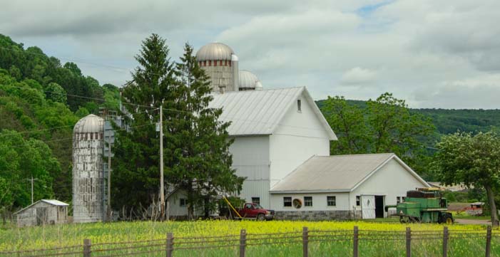 White farm with silo in New York Catkills Mountains in New York