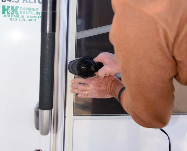 Shrink-wrap RV screen door and use hair dryer to shrink plastic film