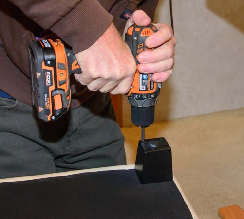 Screwing legs into ottoman with cordless drill