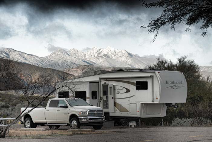 Fifth wheel trailer and Ram 3500 diesel dually truck at campground