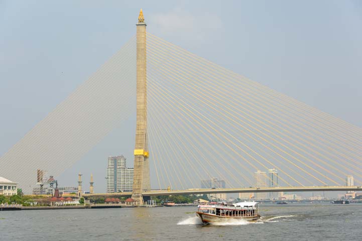 Boat and suspension bridge Chao Phraya River Bangkok Thailand
