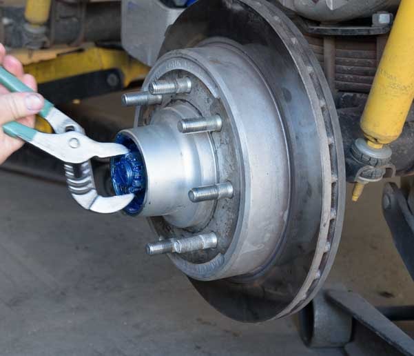 Adjust greased castle nut in fifth wheel trailer disk brake rotor hub-min
