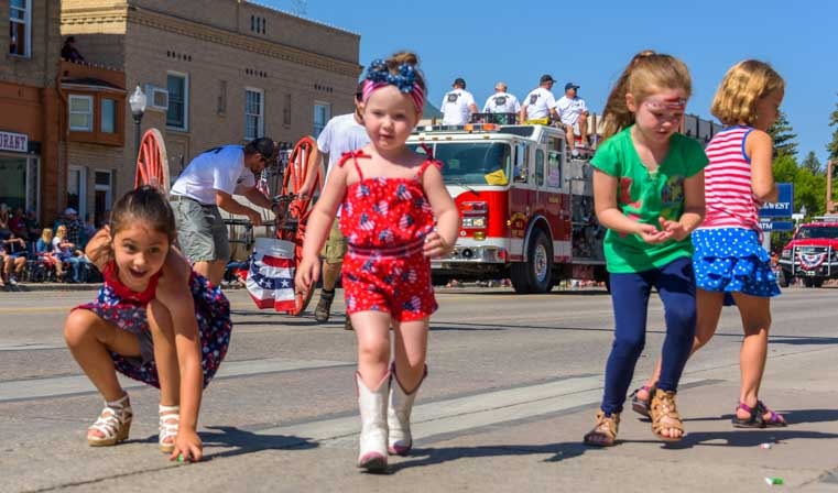 Kids run for candy 4th of July parade Cody Wyoming-min