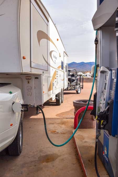 Gas station with RV dump station with triple tow Polaris RZR behind fifth wheel trailer-min
