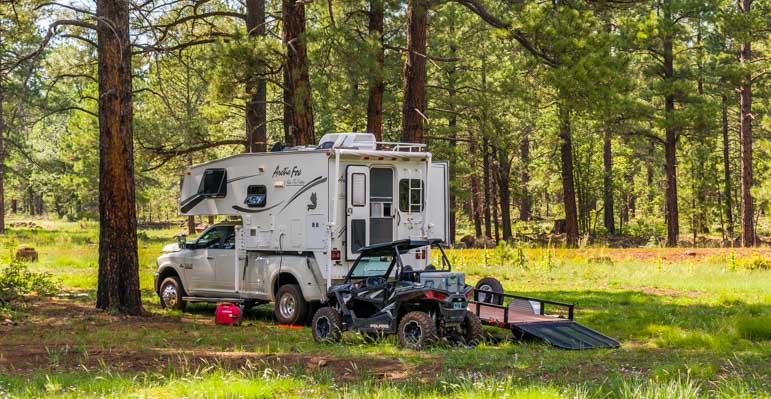 Truck camper and RZR camping in the forest