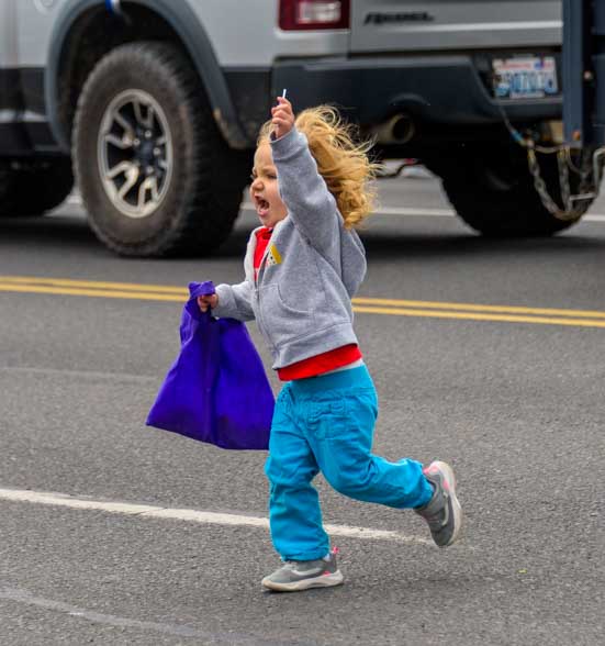 Kid runs for candy in 4th of July parade